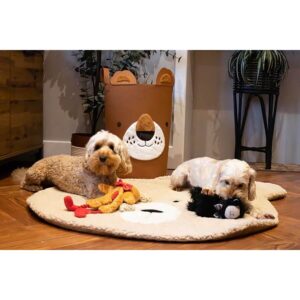 Two playful dogs on a cozy round mat with toys, surrounded by a cute bear-shaped storage. Perfect for pet playtime.