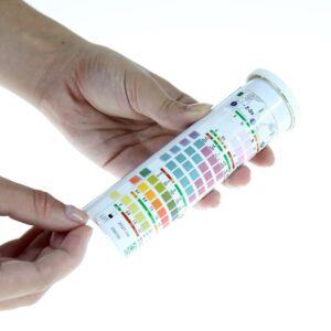 Hands holding JBL Pro Aqua EasyTest 7 in 1 test strips for quick water testing in aquariums.