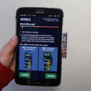 Hand holding smartphone displaying JBL ProScan test results for water analysis including Nitrate levels.