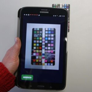 Person using a smartphone to analyze JBL ProScan Test Strips for water quality assessment.