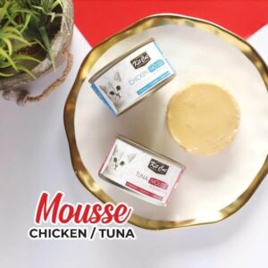 Kit Cat Chicken and Tuna Mousse cans on a decorative plate, showcasing grain-free cat food options for all life stages.